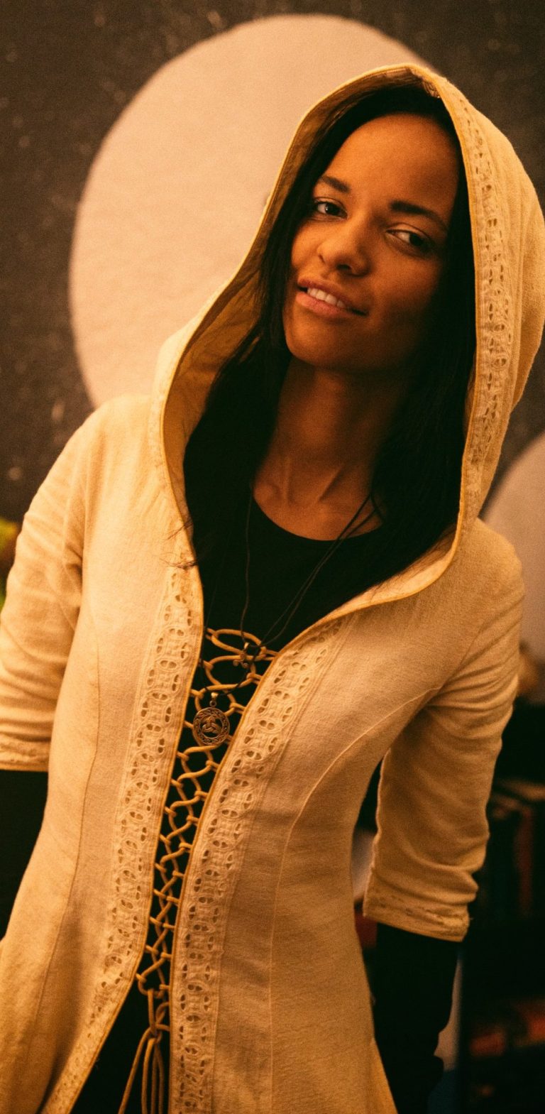 Frau mit Kopfhörern singt vor einem Computer in einem gedämpften, blauen Licht.